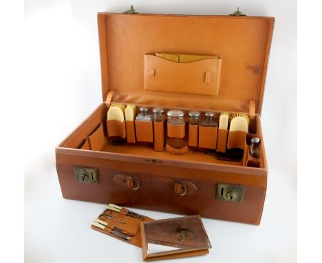 λ A silver-mounted travelling gentleman's toilet set, by Mappin and Webb, London 1928, the covers with engine-turned decorati