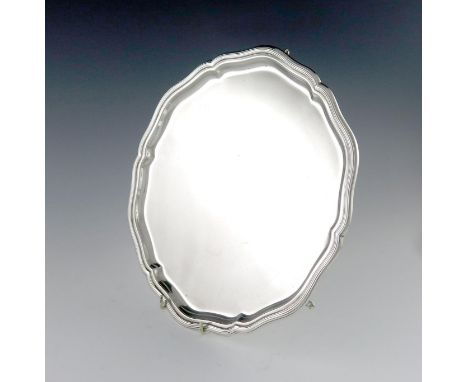 A silver salver, by William Hutton and Sons, Sheffield 1921, circular form, reeded border, on three bracket feet, diameter 30