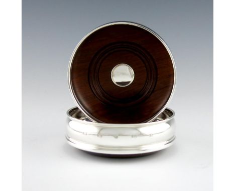 A pair of modern silver wine coasters, by Roberts & Dore Ltd, Sheffield 2001, plain circular form, turned wooden bases set wi