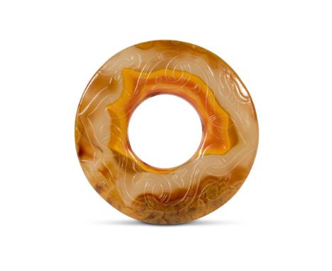 A CHINESE MOTTLED BROWN AND AMBER AGATE BI DISC  QING DYNASTY, 18TH-19TH CENTURY Incised and carved with interlaced serpents 