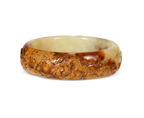A CHINESE MOTTLED GREEN AND BROWN JADE BRACELET  QING DYNASTY (1644-1911)  Carved with animals amongst rocks, including horse