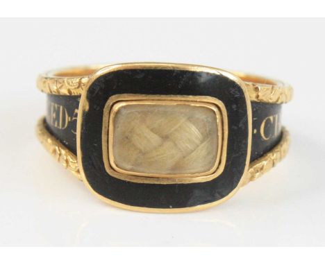 A William IV 18ct gold and black enamel mourning ring, set with a plait of hair under crystal glass, the band inscribed in go