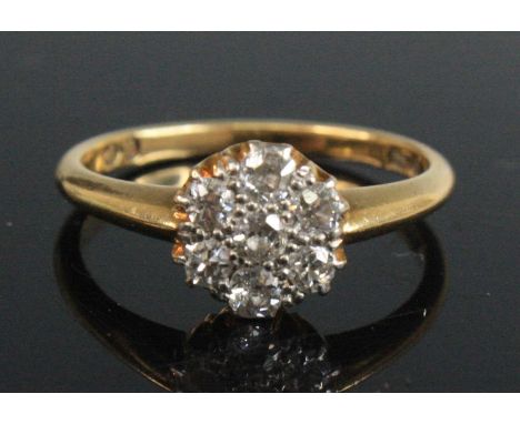 An 18ct gold diamond flower head cluster ring, arranged as seven pavé set round cuts in a hexagonal raised flower head settin