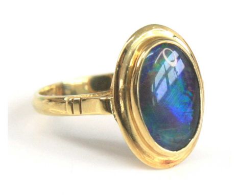 A yellow metal opal triplet ring, the black opal triplet measuring approx 11.55 x 7.39 x 2.65mm, and in an oval bezel setting