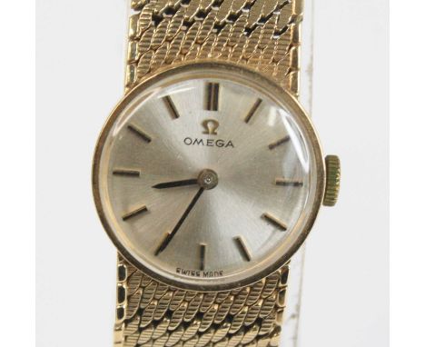 A lady's Omega 9ct gold cased bracelet watch, having a signed champagne dial with baton markers, manual wind movement, to a m