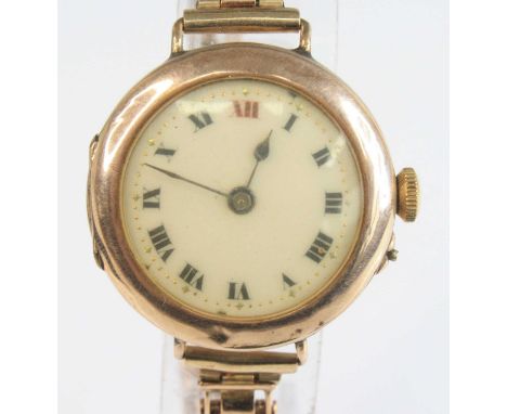 A vintage ladies 9ct gold cased wrist watch having a white enamel Roman dial, manual wind movement, case dia. 27mm on integra