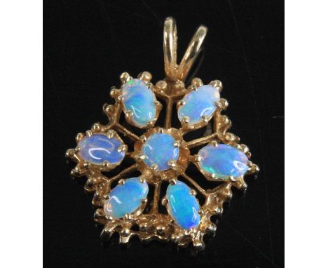 A yellow metal opal flower cluster pendant, featuring a centre round and six oval opal cabochons in claw settings, within a t