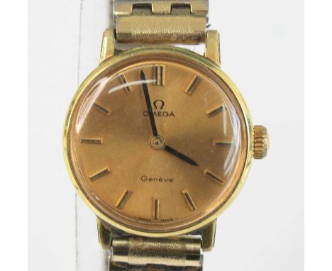 A lady's Omega Geneve gold plated and steel manual wind wristwatch, having a signed champagne dial with baton markers, dia.23
