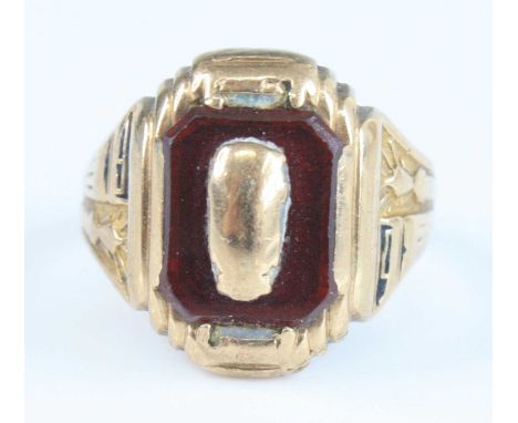 A gent's yellow metal and garnet set signet ring, having carved shoulders, the garnet with canted corners and measuring appro