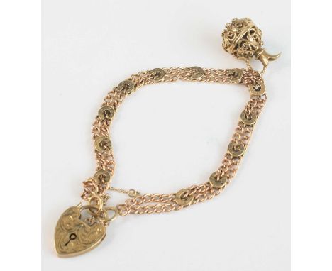 A 9ct gold double-curblink bracelet, with horseshoe sections, heart shaped padlock clasp, supporting single 9ct gold charm fa