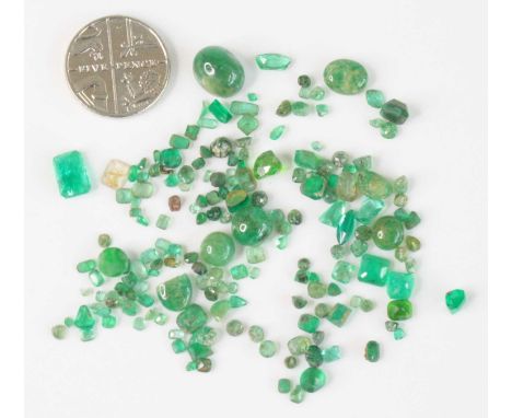 A collection of loose emeralds, being various cuts to include round, cabochon, rough and cushion cut examples, the largest we