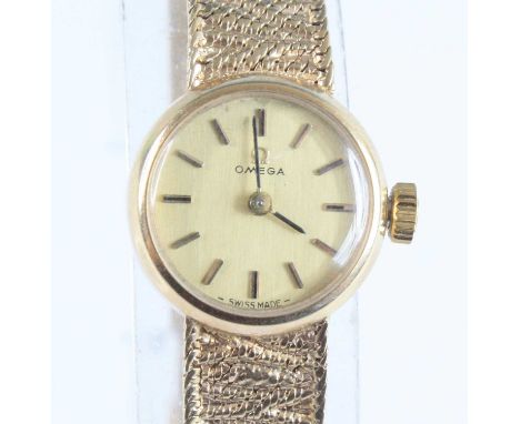 A lady's Omega 9ct gold cased dress watch, having a signed champagne dial with baton markers, manual wind movement, on textur