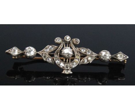 A yellow and white metal diamond bar brooch depicting a harp design, set with 26 Old European and rose cut diamonds, with peg