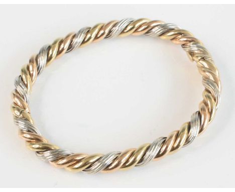 A modern 9ct gold three-colour gold hinged bangle, of ropetwist design, 28.1g, dia.7cmClasp fits tightly. No damage or repair