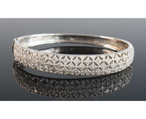 A 9ct white gold diamond hinged oval hollow bangle, featuring a lattice-work section at the front set with 46 melee cut diamo