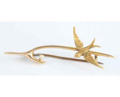 An Edwardian 15ct gold wishbone brooch, set with a swallow and single pearl, 3.8g, 57mm, in probably original fitted red leat