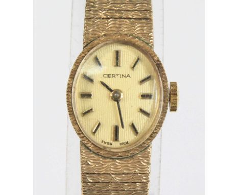 A lady's Certina 9ct gold cased bracelet watch, having an oval Roman dial, manual wind movement, and on textured link bracele