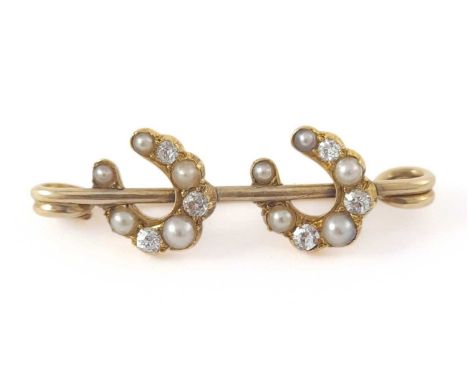 An early 20th century gold pearl and diamond double horseshoe brooch
