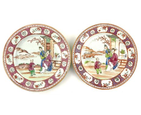A pair of Chinese export Mandarin pattern plates, Qianlong style decoration, depicting a child reading to his parents in a ga