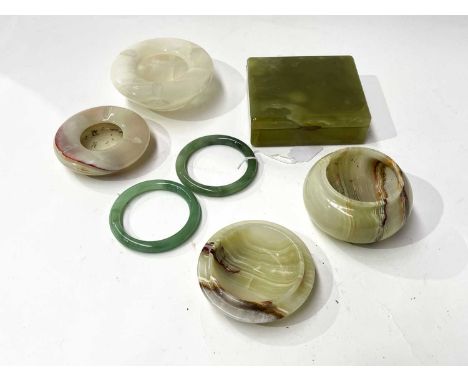 A small collection of green hardstone, a lidded pot, two small bowls, ashtray, a box, with two jade-coloured bangles on stand