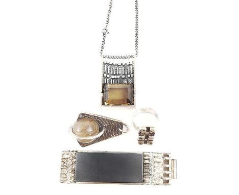 Erich Frey, a pendant, the polished steel within a raised setting, the borders decorated in relief with geometric motifs, hei