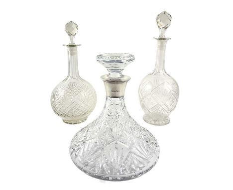 A Royal Doulton cut crystal ships decanter with silver hallmarked mouth, and two globe and stem decanters, all with stoppers 
