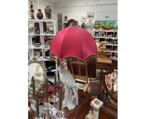 A white porcelain figural table lamp in the form of a parrot, red tasselled shade, figure 56cm tall 