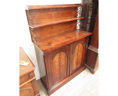 Circa 1820 - A Regency rosewood chiffonier with raised shelves on decorative brass supports over Cathedral arch panel door ba