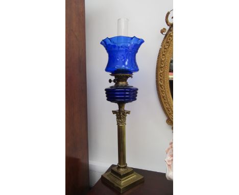 An early 20th Century English made column form oil lamp with blu art nouveau shade and ribbed blue glass reservoir, square st