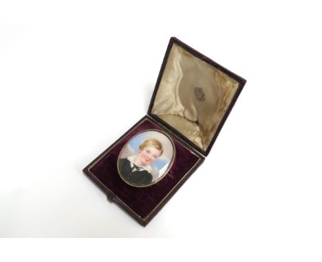 A 19th Century miniature watercolour on oval ivory panel, portrait of a young boy wearing a white shirt and black jacket, set