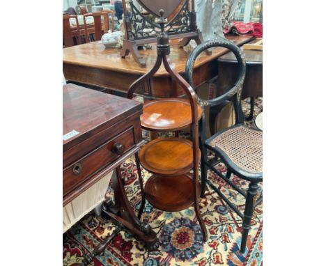 An Edwardian line inlaid mahogany three tier cake stand in the manner of 'Liberty &amp; Co' the finial handle over circular d