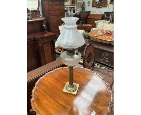 A late 19th Century/early 20th Century oil lamp with brass column base, cut glass reservoir. Highly ornate conical shade with