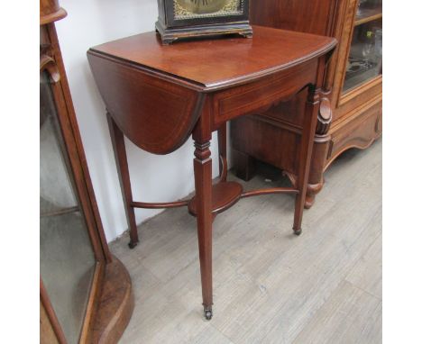 Attributed to "Maple &amp; Co" an Edwardian crossbanded mahogany oval top lamp table the rising leaves over a bow front singl