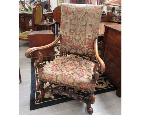 A walnut Carolean revival tapestry upholstered armchair the outswept scroll arms on scroll forelegs joined by a carved front 
