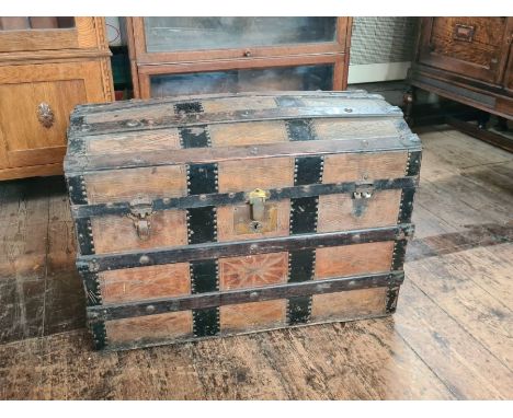 Vintage dome top trunk with metal and wooden bandings and decorative leather panels, original interior.