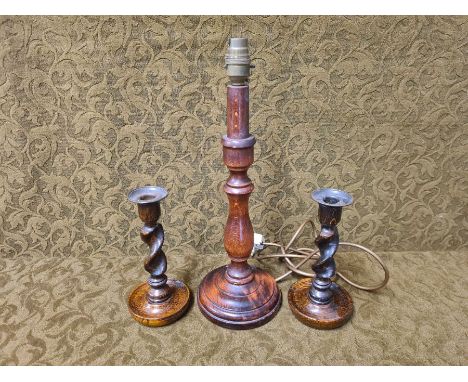 Polished beechwood table lamp and a pair of barley twist candlesticks.