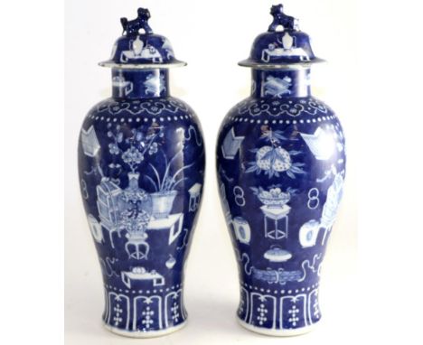 A pair of Chinese porcelain baluster vases and covers, painted underglaze blue with precious objects, bears Kangxi reign mark