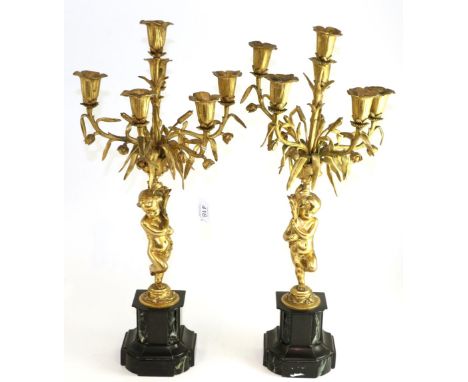 A pair of gilt metal five-light candelabra in 18th century style, with cherub supports on marble bases, 58cm high