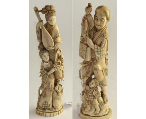 A pair of Japanese ivory okimonos, Meiji period, as a family of entertainers she with a lute he with a puppet 28.5cm