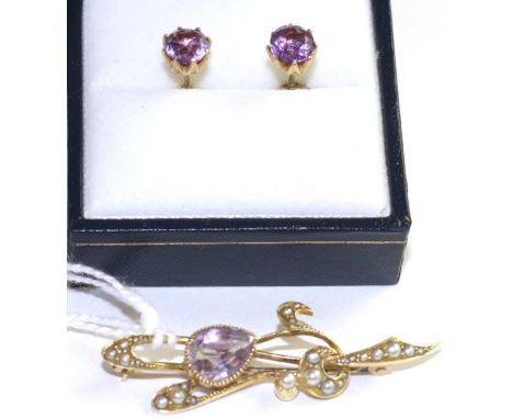 An Art Nouveau amethyst and seed pearl brooch, an oval cut amethyst in a yellow milgrain setting to whiplash motif bar set th