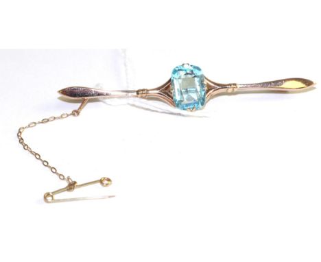 An aquamarine bar brooch, a cushion cut aquamarine in a yellow double claw setting, to a forked tapering bar, length 6.7cm  T