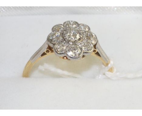 A diamond cluster ring, an old cut diamond within a border of smaller old cut diamonds in white milgrain settings, to knife e