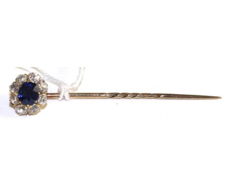 A sapphire and diamond stick pin, a round cut sapphire within a border of old cut diamonds in yellow claw settings, total est