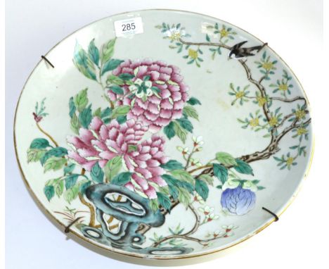 A Chinese porcelain sauce dish, Kangxi reign mark but not of the period, painted with famille rose enamels with flowering peo