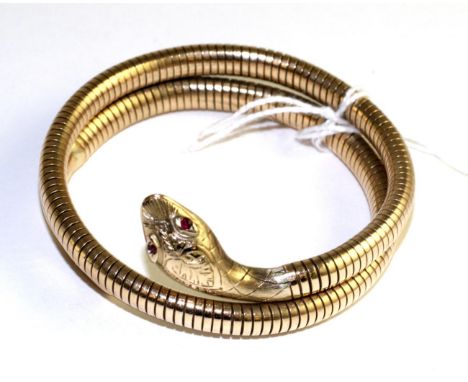 A 9 carat gold snake bangle, with faceted ruby eyes and foliate engraved head to a coiled articulated bodyThe bracelet is in 