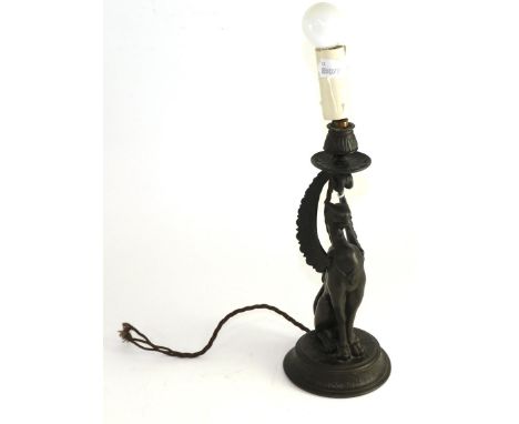 A bronzed spelter candlestick, late 19th century, modelled as a griffin on a circular base, 31cm high, converted to electrici