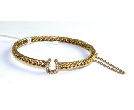 A seed pearl set bangle, a central horseshoe set with seed pearls to a curb link hinge opening bangle, measures 6cm by 5cm Th