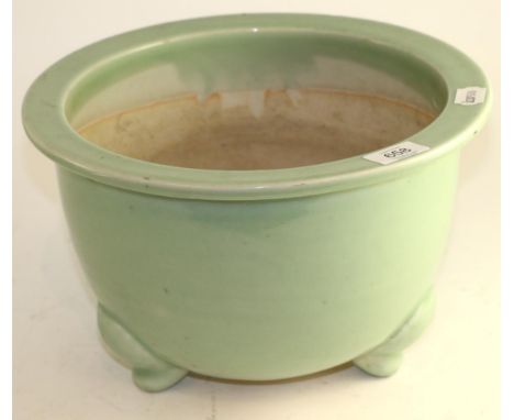 A Chinese celadon ground jardiniere, on three scroll feet, 32cm diameter