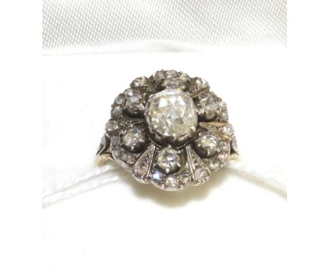 A diamond cluster ring, set with rose cut diamonds in white claw settings, on a yellow engraved shank, total estimated diamon