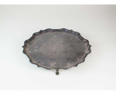 A silver salver, Roberts &amp; Belk, Sheffield 1970, of circular form with pie crust rim and raised on four stepped feet, 31c